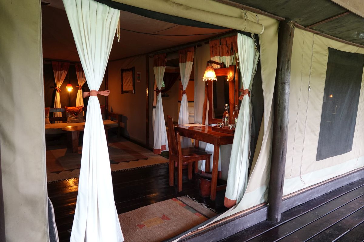 Eingang eines Safari-Zelts im Tipilikwani Mara Camp mit offenem Wohnbereich und gemütlicher Einrichtung.