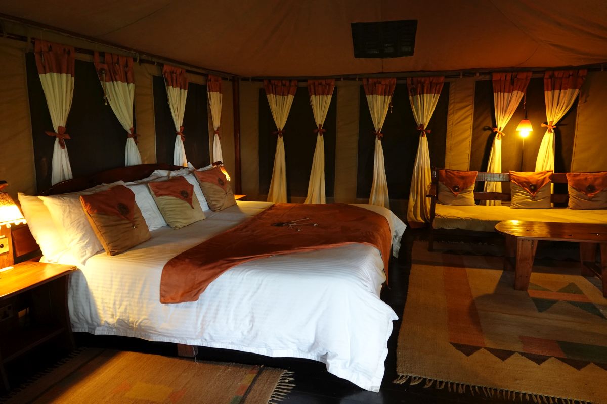 Geräumiges Safari-Zimmer im Tipilikwani Mara Camp mit Doppelbett und gemütlicher Sitzecke.