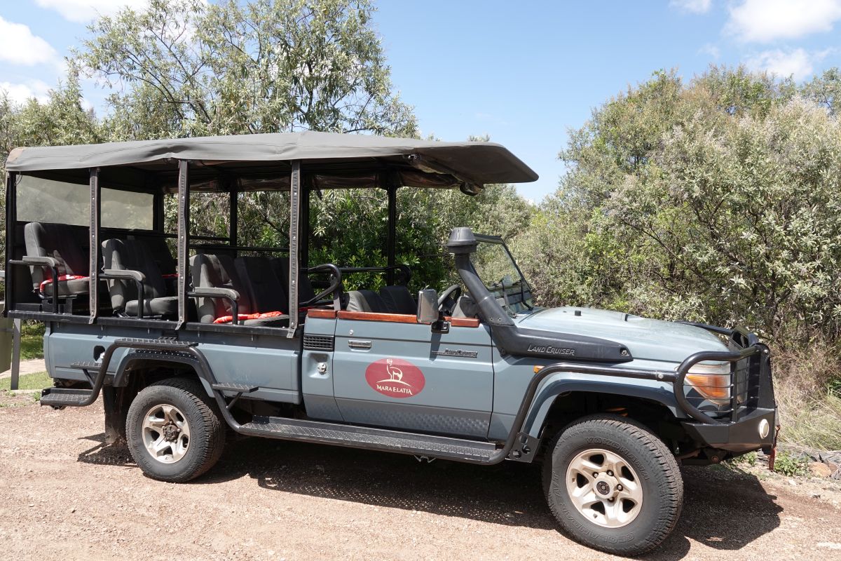 Offenes Safari-Fahrzeug des Elatia Mara Camp inmitten der Natur der Masai Mara.