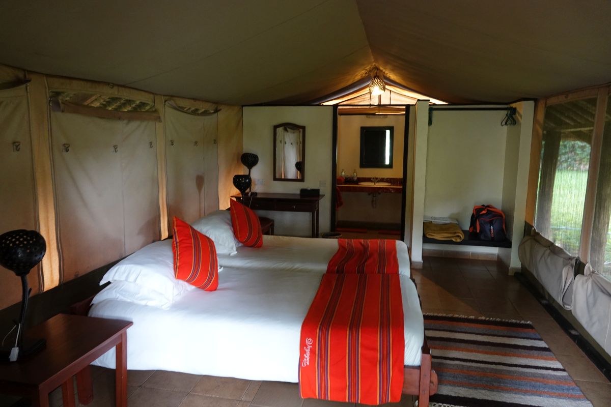 Safari-Zeltzimmer mit Doppelbett und Sitzbereich.