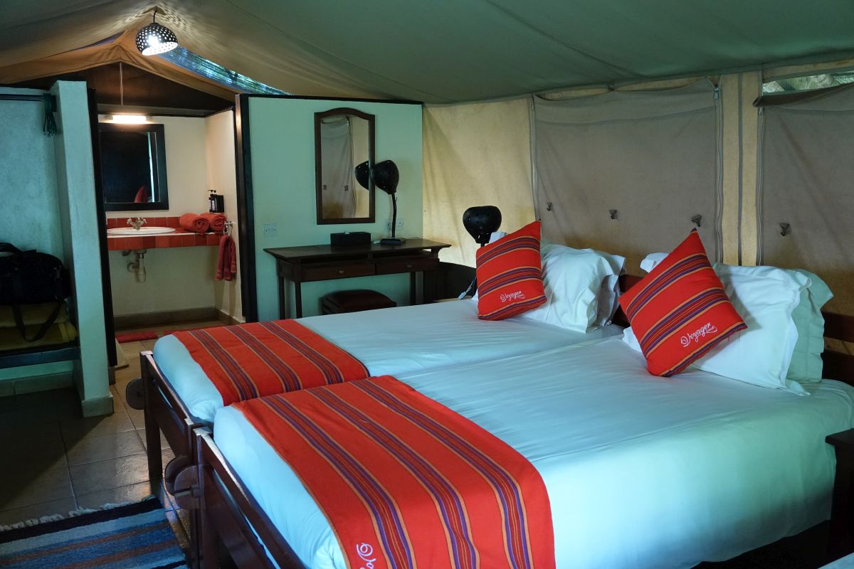 Safari-Zeltzimmer mit Doppelbett und farbigen Akzenten.