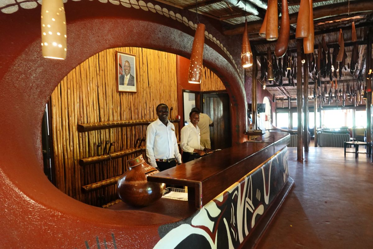 Rezeptionsbereich der Amboseli Serena Lodge mit traditionellem afrikanischem Design, Holzelementen und freundlichem Personal.