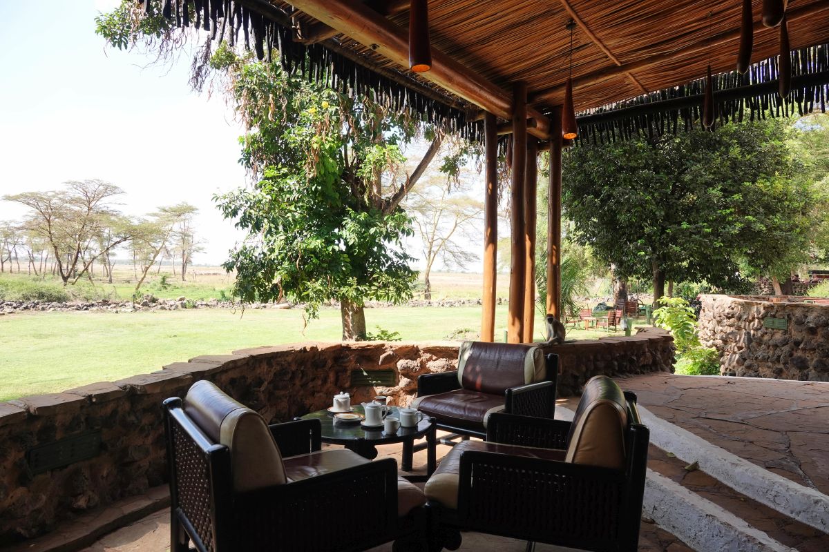 Offener Lounge-Bereich der Amboseli Serena Lodge mit gemütlichen Sitzgelegenheiten und Blick in die grüne Landschaft.