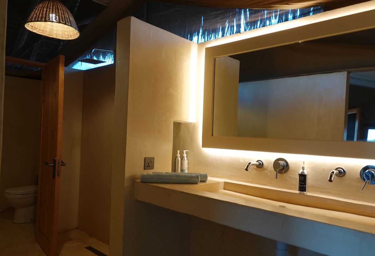 Badezimmer mit Waschbecken und großem Spiegel im Kudu Safari Camp.