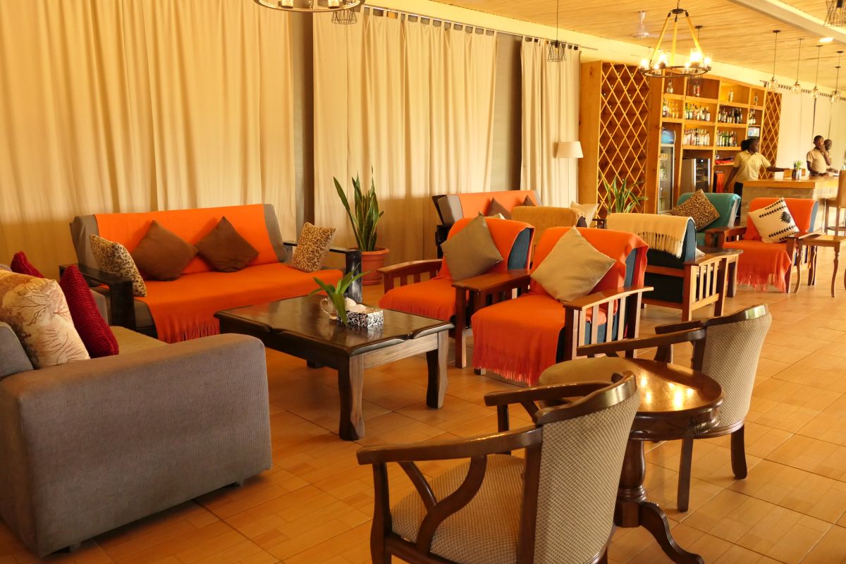 Loungebereich mit Sofas, Stühlen und Tischen sowie einer Bar im Hintergrund