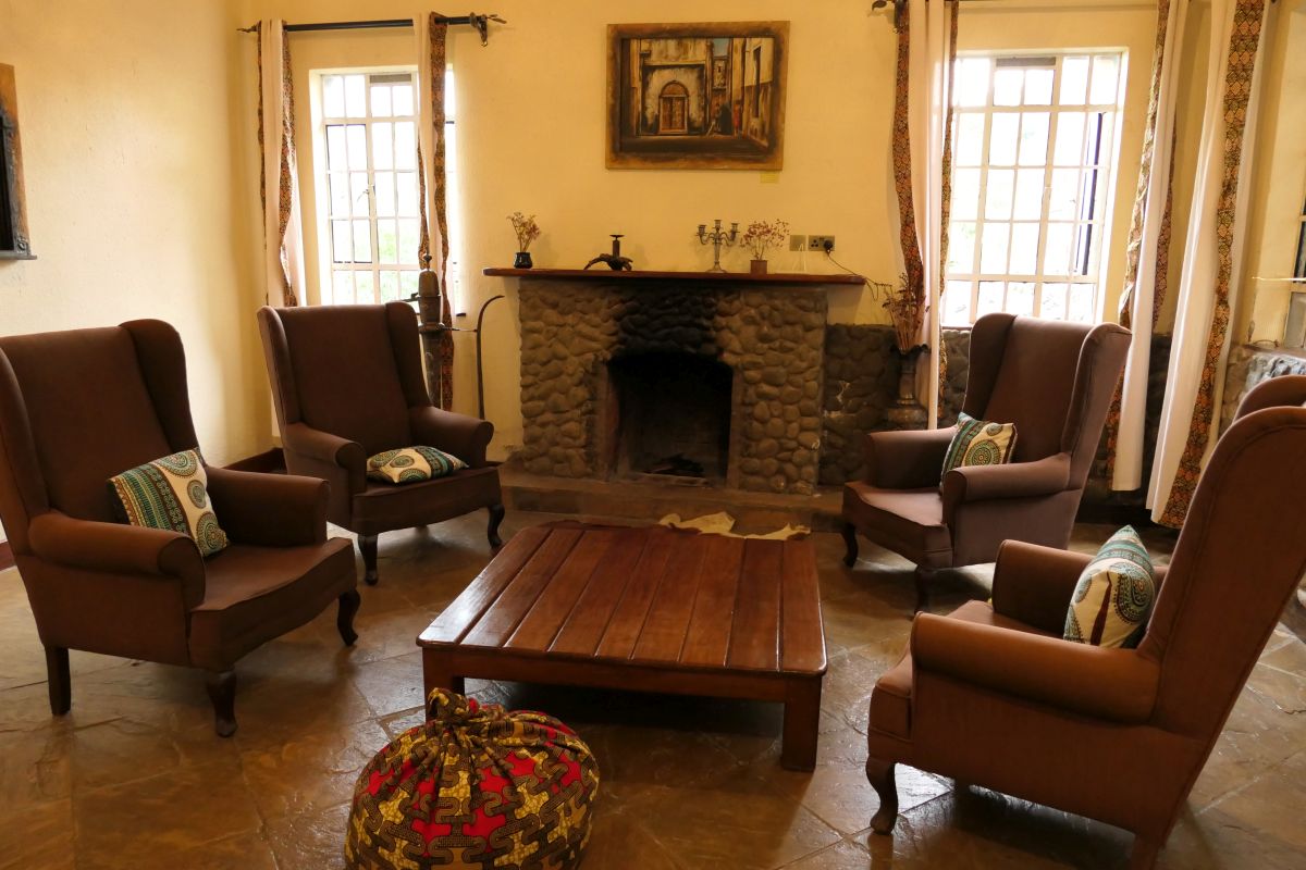 Kaminzimmer mit zentralem Kamin, 4 großen Sesseln, Tisch und zwei Fenstern