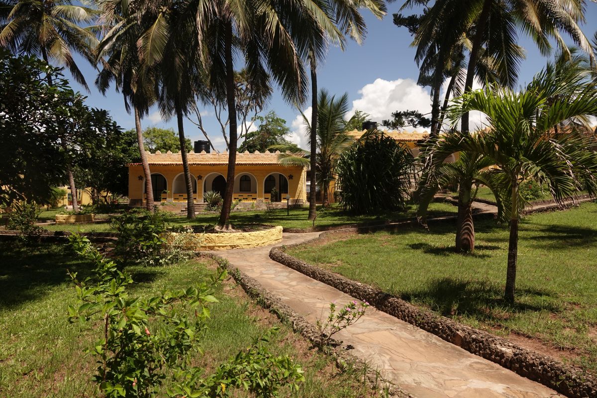 Wege in der gepflegten Gartenanlage mit gelbem Bungalow