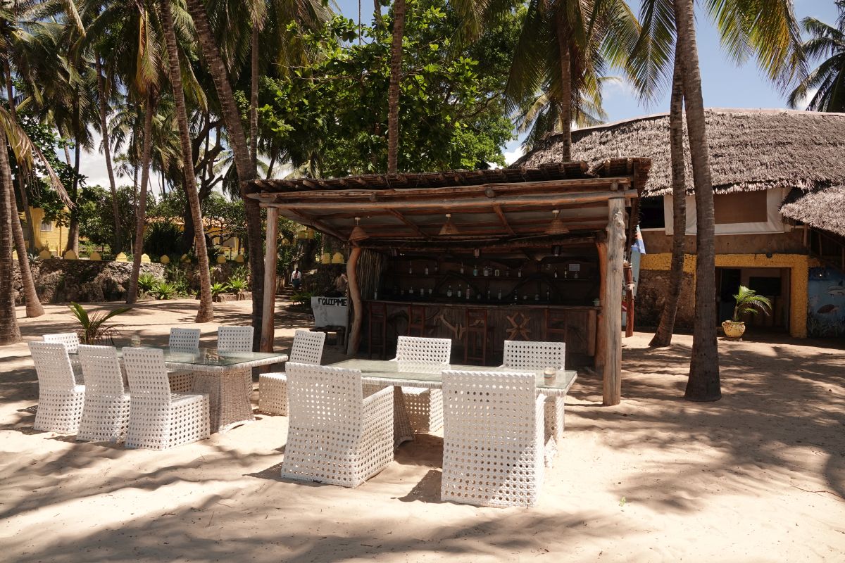 Beach-Bar im Hotel Coconut Beach Boutique Lodge mit Tischen und Strandsesseln